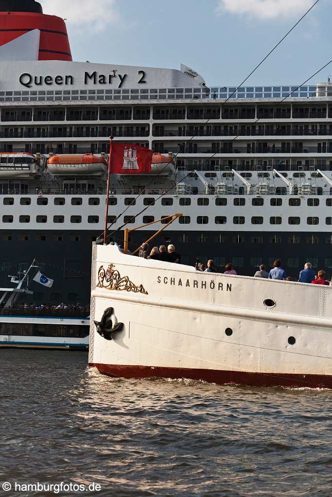 bz0469 Das Kreuzfahrtschiff "Queen Mary 2" liegt im Hamburger Hafen. Das historische Dampfschiff "Schaarhoern" faehrt mit faehrt mit Passagieren am Luxusliner vorbei