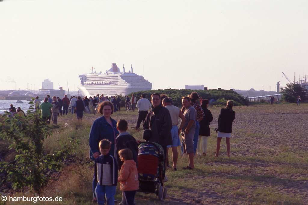 id101072 Das Kreusfahrtschiff Queen Mary 2 laeuft aus dem Hamburger Hafen aus. Schaulustige am Elbufer.