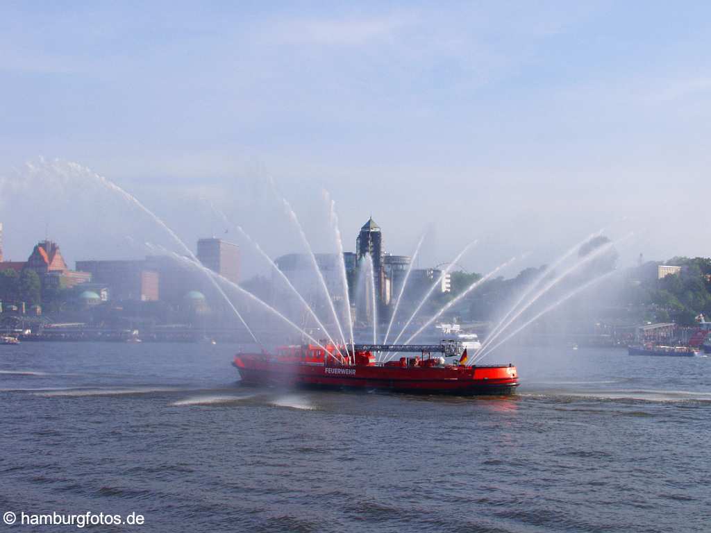 id101078 Das Kreusfahrtschiff Queen Mary 2 laeuft aus dem Hamburger Hafen aus. Feuerwehrboot spritzt Fontainen.´