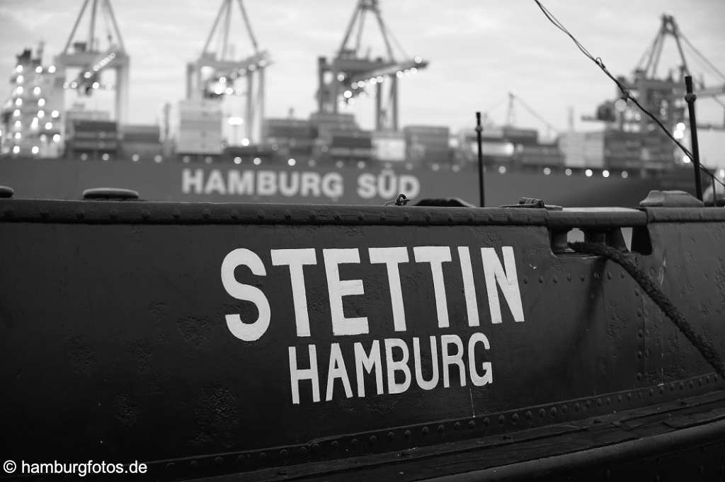 hamburg_schwarzweiss_067 Bordwand des Eisbrechers Stettin mit Schriftzug: STETTIN HAMBURG, im Hintergrund der HHLA Containerterminal mit rotem Containerschif der Reederei Hamburg S¸d.