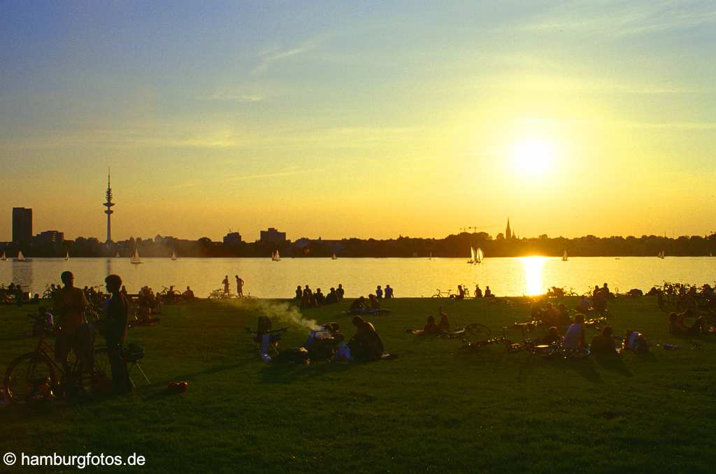 id100949 Skyline von Hamburg: Sonnenuntergang an der Aussenalster, Menschen auf Wiese.