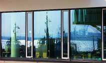arc015 Die Hafen-Skyline von Hamburg spiegelt sich in Fenstern.