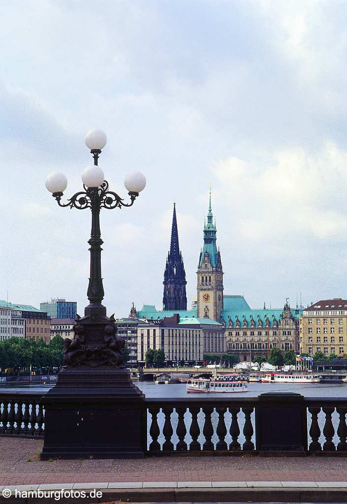 skyline009 Skyline von Hamburg: Blick ueber die Binnenalster auf den Jungfernstieg, von links: St. Nikolai, das Hamburger Rathaus, im Vordergrund die Lombardsbruecke mit einem Kandelaber.