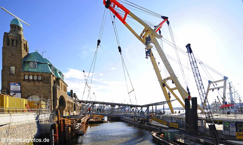 id113515 Hamburg Landungsbruecken, ein grosser Schwimmkran ersetzt Brueckensegmente, dass Wetter ist schoen, der Himmel ist blau und die Sonne strahlt.