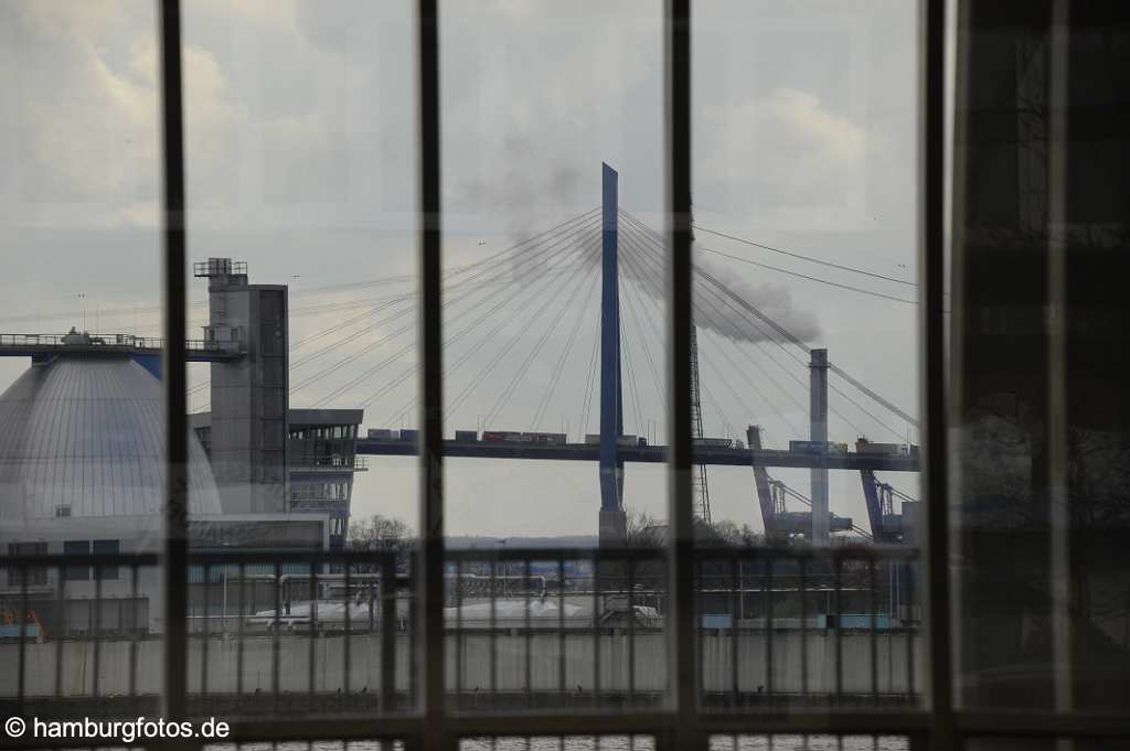 id500091 Blick durch eine Fentserscheibe auf das Klaerwerk und die Koehlbrandbruecke.