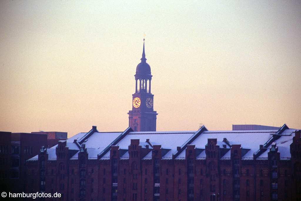 id101125 St. Michaelis das Wahrzeichen von Hamburg sowie Hauptkirche. Michel im Winter mit Schnee auf den Daechern der Speicherstadt.