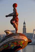 id502133 Hamburg im Sonnenaufgang - Hamburger Hafen mit St. Michaelis im Vordergrund eine Nana Skulptur der kuentlerin Niki de Saint Phalle